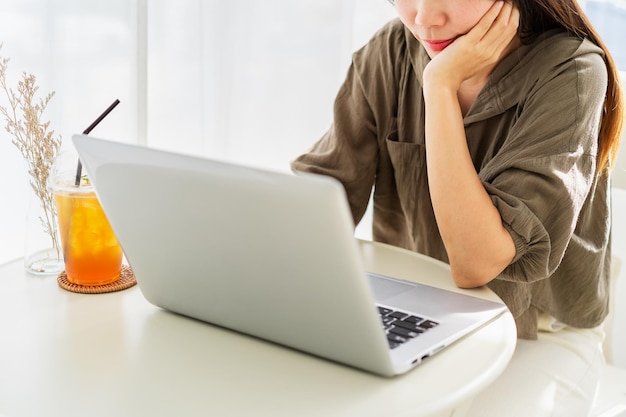 Young woman sitting and working on laptop at coffee shop