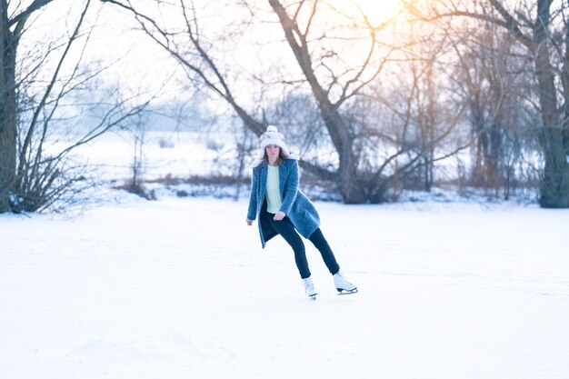 young woman skating on a frozen pond