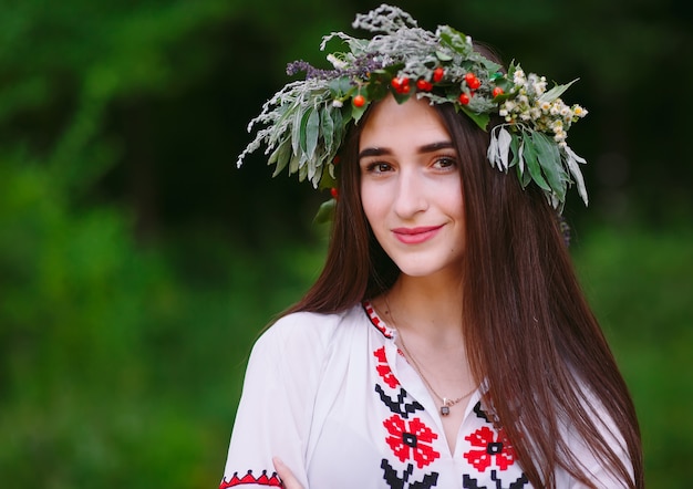 A young woman of Slavic appearance with a wreath of wild flowers on the MidSummer.