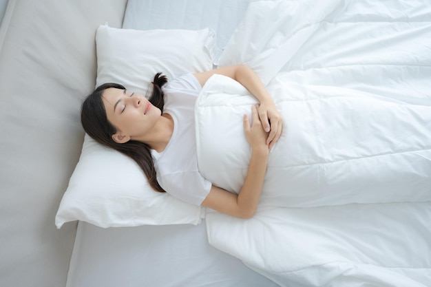 Young woman sleeping in a comfortable white bedroom