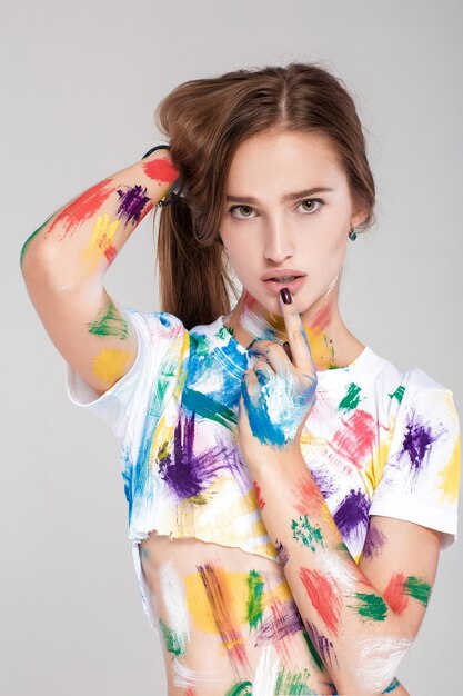 Young woman smeared in multicolored paint