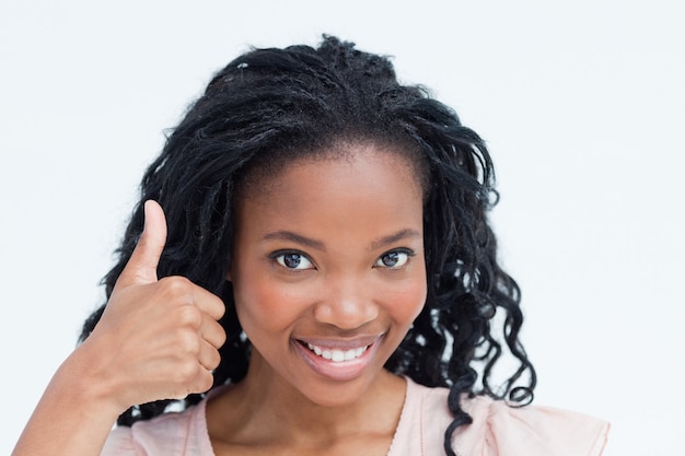 A young woman smiling at the camera with her thumb up