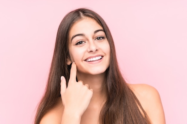 Young woman smiling isolated on pink