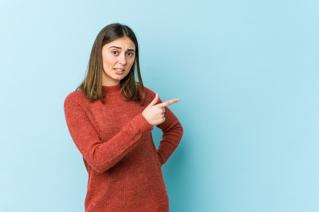 Young woman smiling and pointing aside