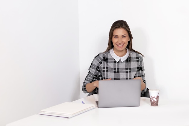 Young woman smiling working on laptop in office