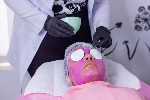 young woman in a spa salon woman in pink mask