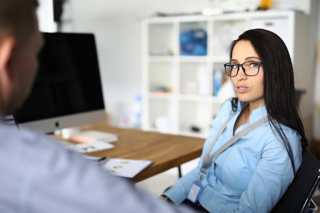 Young woman speaks with a man in the workplace