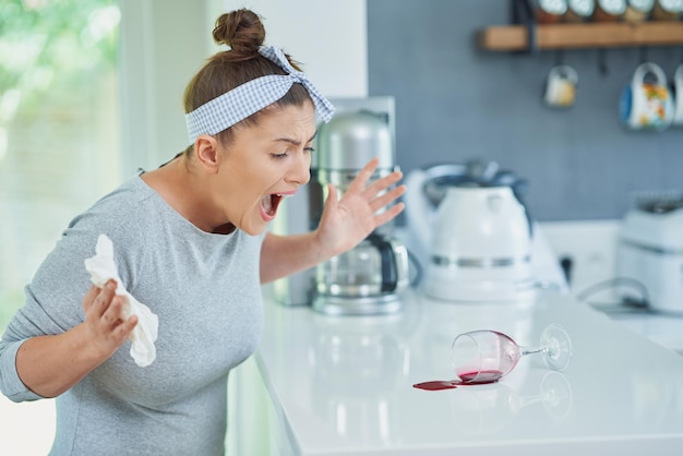 Young woman and spilled wine in the kitchen