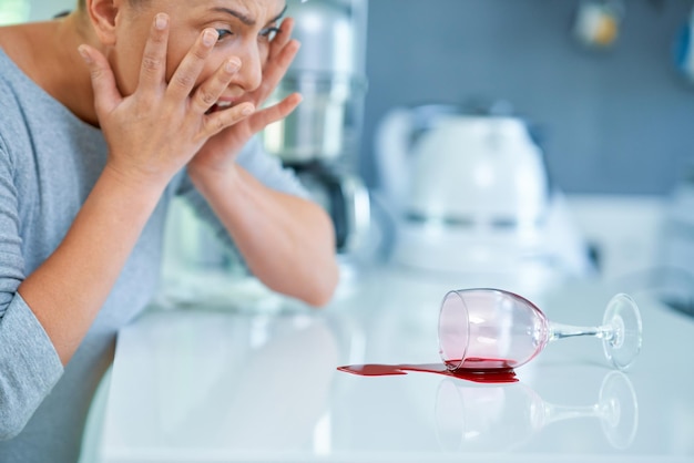 Young woman and spilled wine in the kitchen