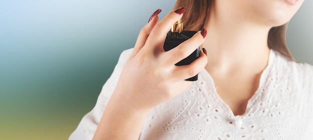 Young woman splashing perfume