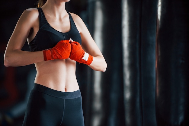 Young woman in sportive wear is in the gym having exercise day. Conception of boxing.