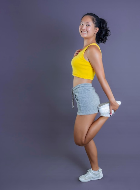 Young woman in sportswear of asian ethnicity isolated on gray background