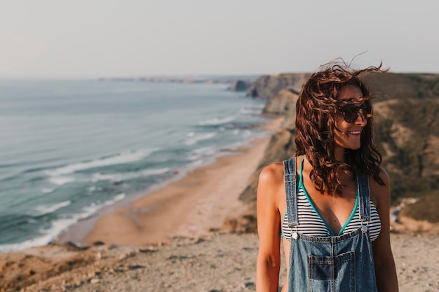 Photo young woman standing at beach against sky