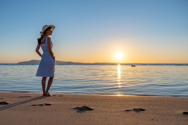 Young woman standing on the empty sand beach