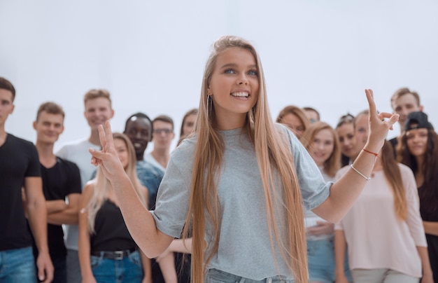 Photo young woman standing in front of a casual group of young people