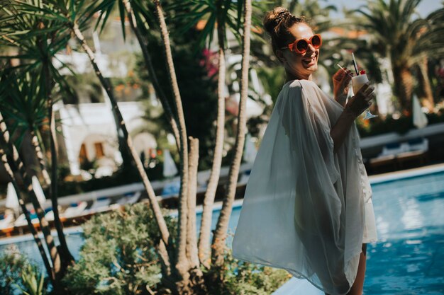 Photo young woman standing next to the pool