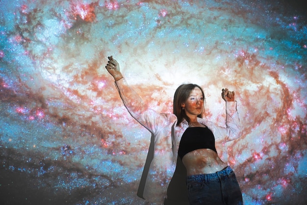 Young woman standing in universe texture projection