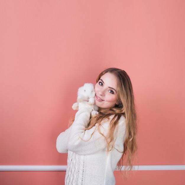 Young woman standing with cute rabbit 