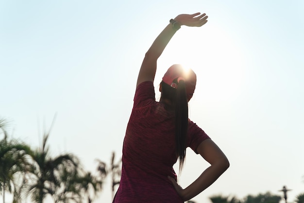 Young woman stretching before running Sport girl preparing to run in the park