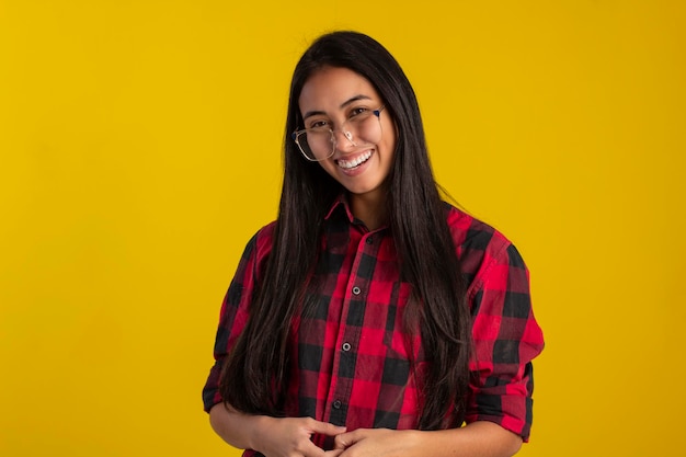 Young woman in studio photo wearing plaid shirt and glasses