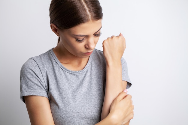 Young woman suffering pain on hands and fingers