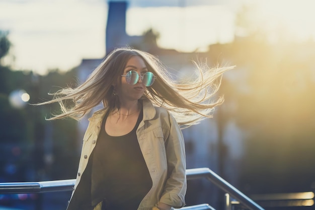 Young woman in sunglasses have fun with outdoor sunset in the background