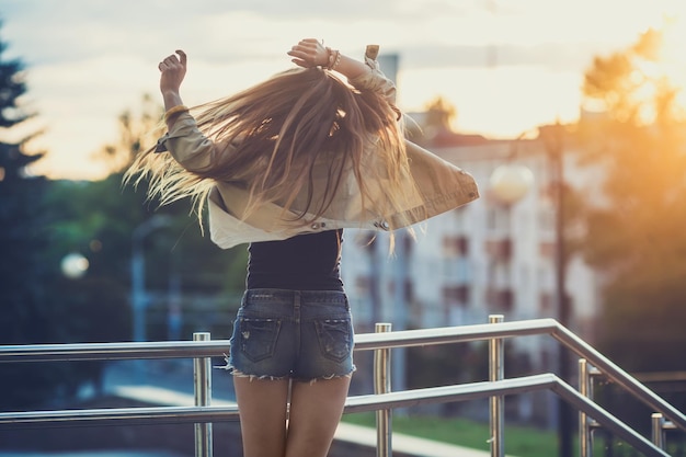 Young woman in sunglasses have fun with outdoor sunset in the background