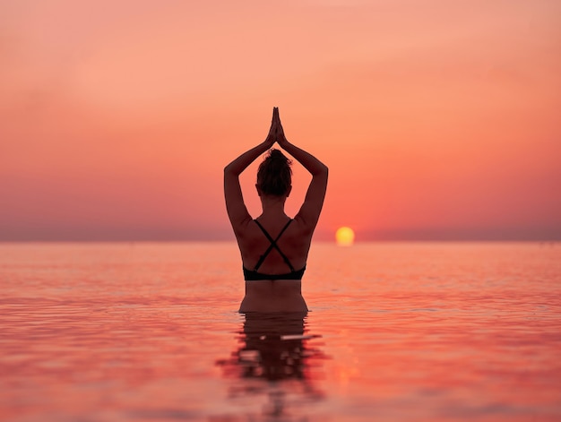 Young woman swimming in the sea on sunrise