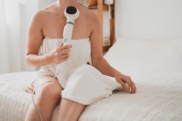 Young woman takes care of her body  uses body massager against cellulite and regenerates muscles