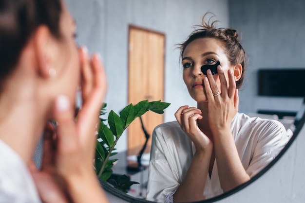 Young woman takes care of her facial skin at home.