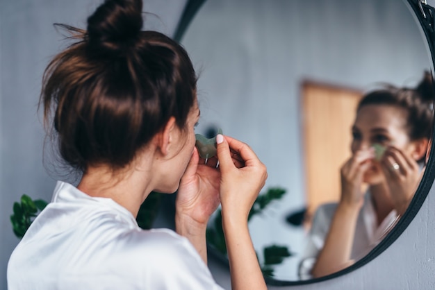 Young woman takes care of her facial skin at home.