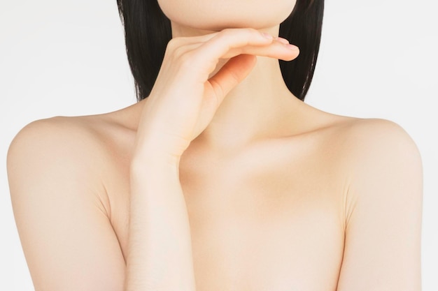 young woman takes care of the skin of the body touches the skin on the neck after moisturising