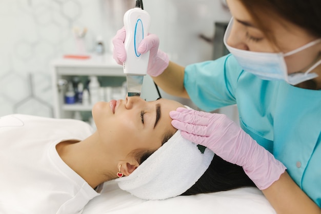 Young woman taking beauty procedure in spa salon