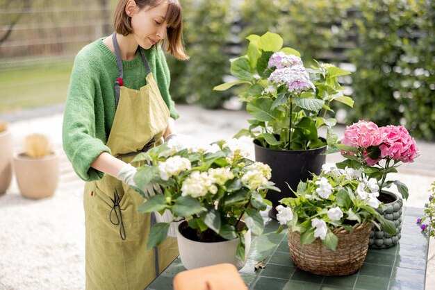 Young woman taking care of flowers in the garden