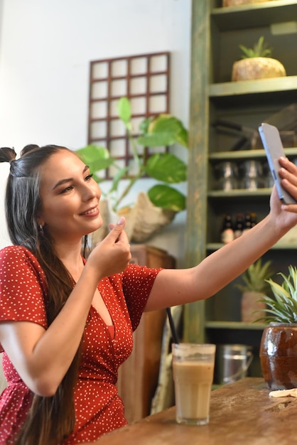 Young woman taking selfie in a coffee shop