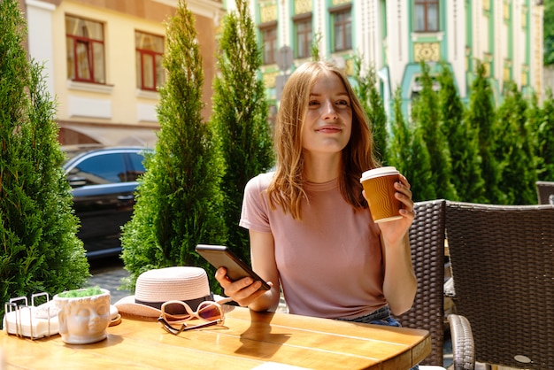 young woman talking on the phone in a cafe on a summer terrace