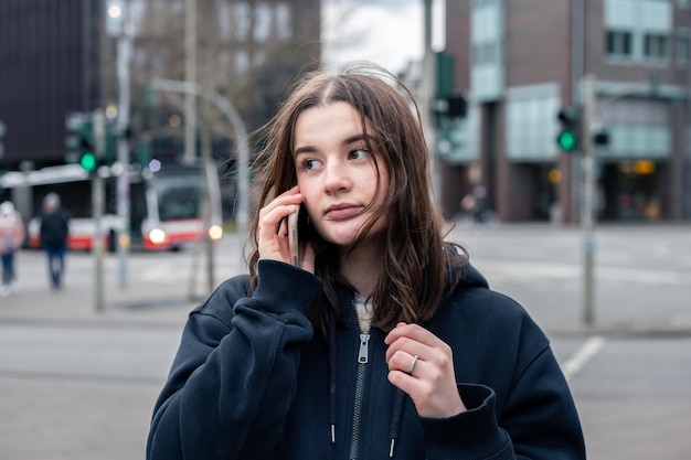 A young woman talking on the phone in the city on the street