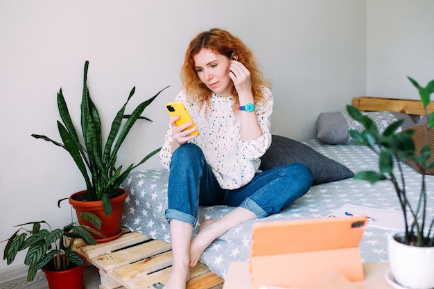 Young woman talking on smartphone from home on video call