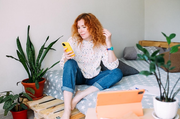 Young woman talking on smartphone from home on video call