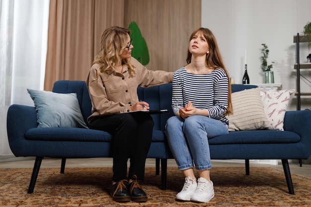 Young woman talks with female psychologist at home