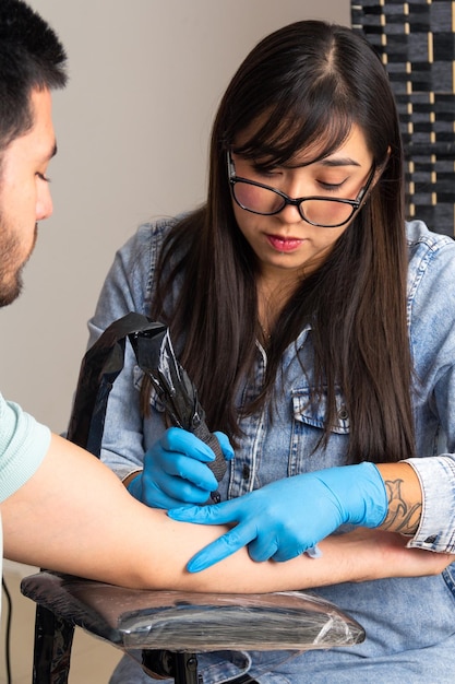 young woman Tattoo artist in a studio