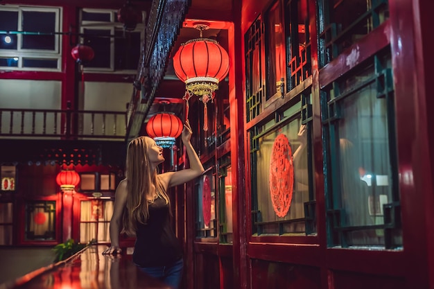 Young woman tourist looks at the chinese traditional lanterns chinese new year travel to china