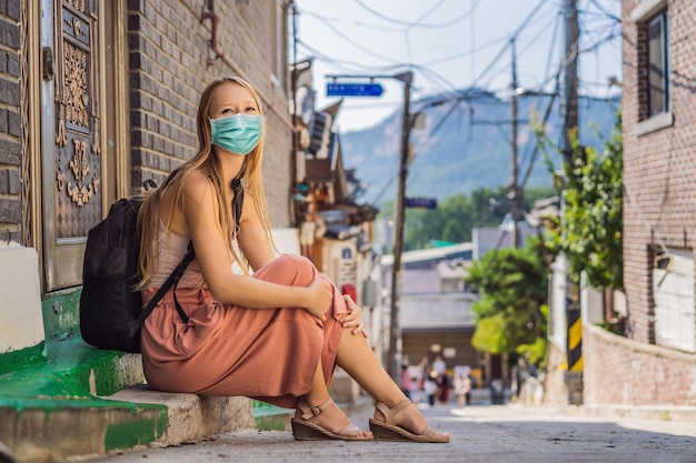 Young woman tourist in medical mask in bukchon hanok village is one of the famous place for korean