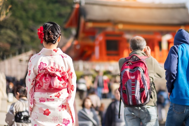 Young woman tourist wearing kimono enjoying with colorful leaves in Kiyomizu dera temple, Kyoto, Japan. Asian girl with hair style in traditional Japanese clothes in Autumn foliage season