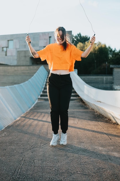 Young woman training jumping the rope at an urban scenario Exercising to lose weight