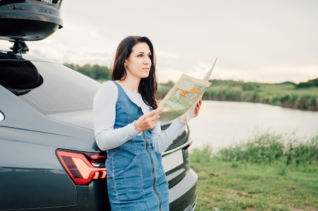 Young woman travel the roads in a car look at the map Vacation concept