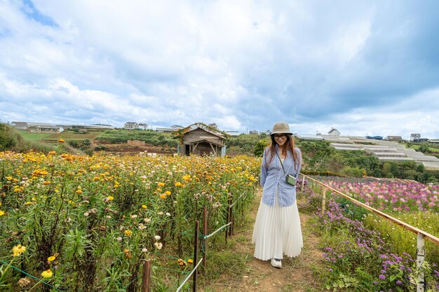 Young woman traveler enjoying with blooming yellow xerochrysum bracteatum garden in Dalat Vietnam Travel lifestyle concept