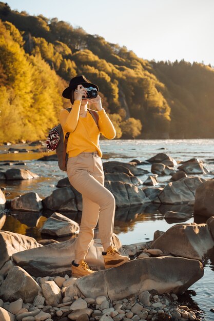 Young woman traveler is taking pictures of nature on a camera