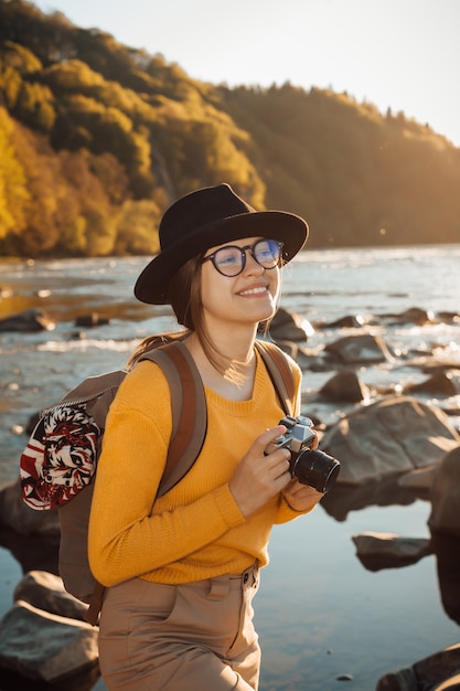 Young woman traveler is taking pictures of nature on a camera