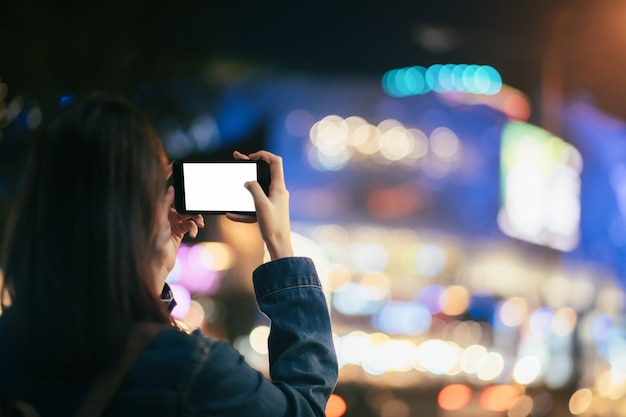 Young woman traveler taking photo with mobile phone.